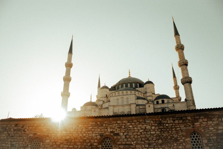 the sun is shining behind a building with two towers