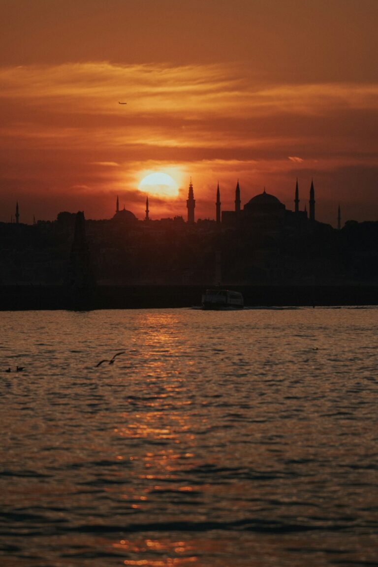 a large body of water with a sunset in the background