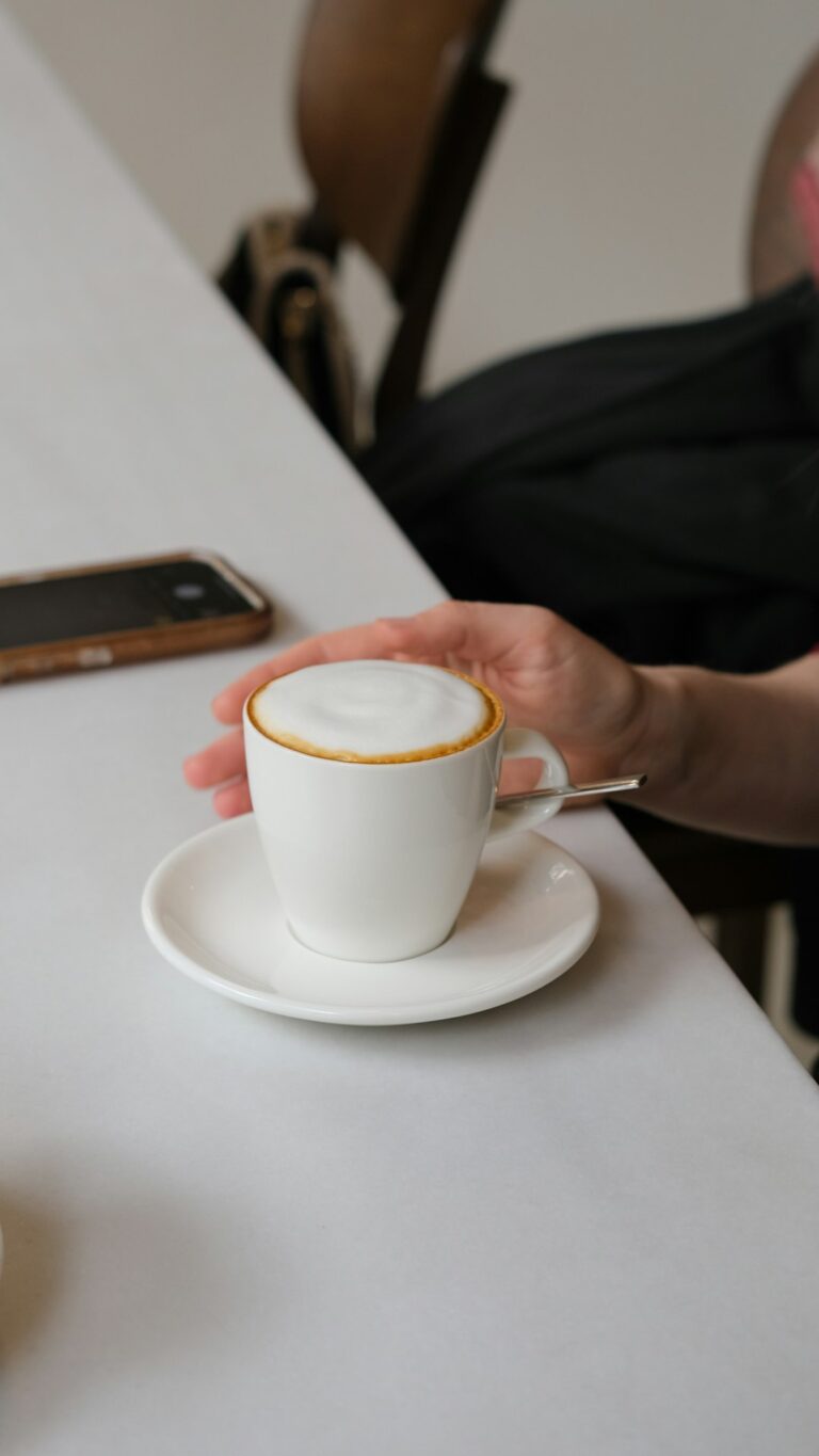 A person sitting at a table with a cup of coffee