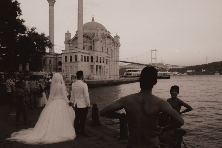 A man and a woman standing next to a body of water